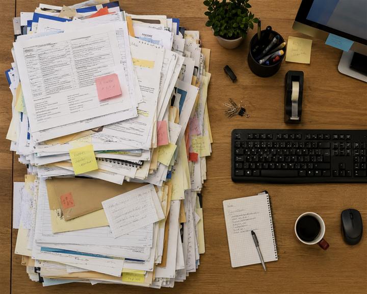 Une pile de documents qui déborde d'un bureau
